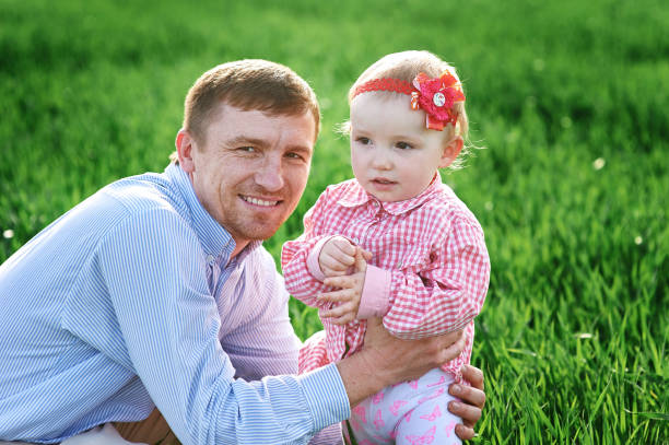 istock Little girl with dad walking on a summer meadow 826374652