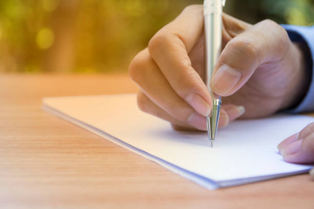 istock Close up hand writing on paper. Close up people writing on paper. 826389634