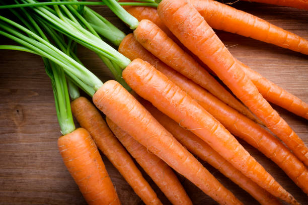 istock Fresh carrots on the wooden background. 826408920