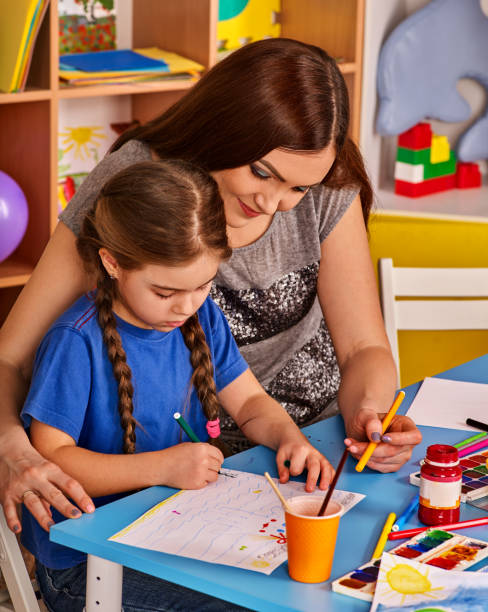 istock Small students girl painting in art school class. 826410824