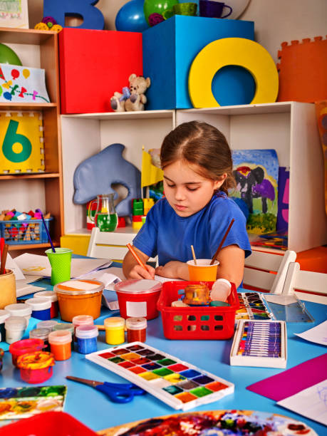 istock Small students girl painting in art school class. 826412098