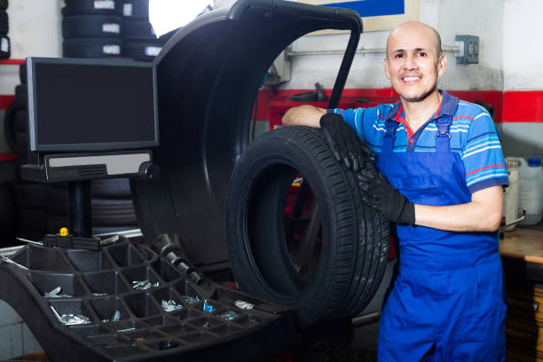 istock Mature male technician holding car wheel ready to work with balancing machinery at workshop 826415598