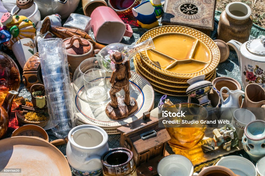 pile of household things and decorative objects at welfare pile of household things, various dishes and decorative objects at boot sale for second hand, recycling or over-consumption society at outdoor welfare Thrift Store Stock Photo