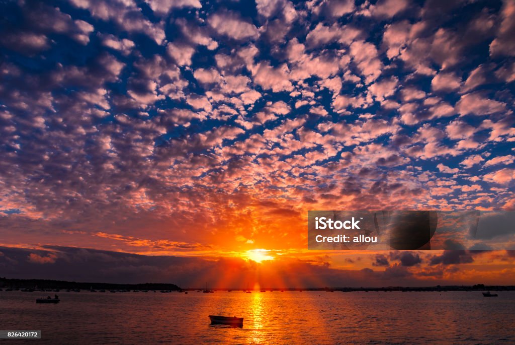 Sunset at Sandbanks in Dorset Beatiful rich colourful scene as the sun sets in Poole Harbour around the Sanbanks peninsula Bay of Water Stock Photo