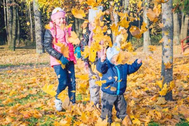 istock Children play in autumn Park.Falling leaves from trees. 826421112