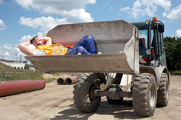 Man asleep in bucket of earth mover  lazy construction laborer stock pictures, royalty-free photos & images