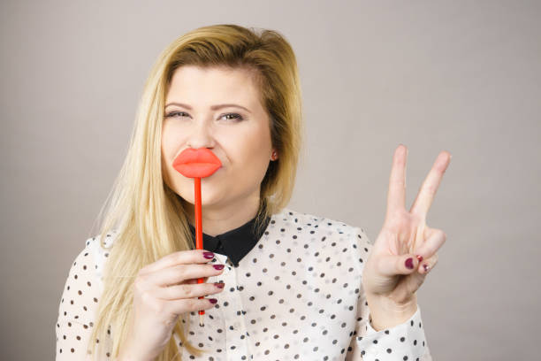 istock Happy woman holding fake lips on stick 826437792