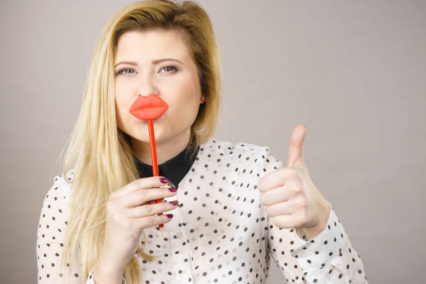 istock Happy woman holding fake lips on stick 826441636