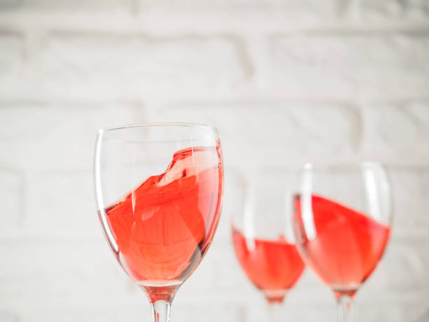 istock Three wineglass with pink wine on white brick wall background 826442912