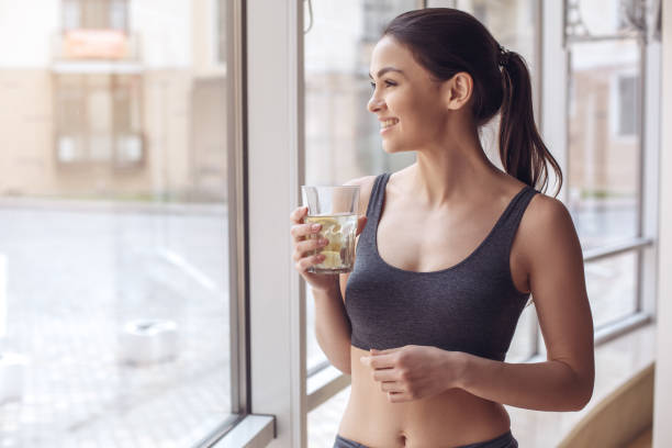 entraînement de la jeune femme dans le mode de vie sain gym - water women glass healthy eating photos et images de collection