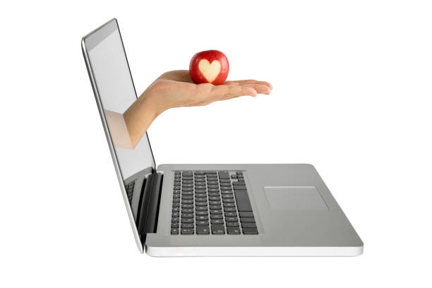 istock Human hand coming out from computer screen, Hand holding apple 826448860
