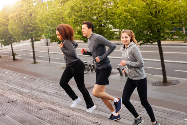 istock Athletic young people running up on city stairs 826453412