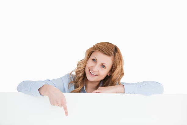 istock Blond woman pointing at an empty whiteboard 826460614