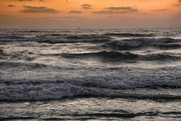 waves crashing during sunset - sailboat sunset tel aviv sea imagens e fotografias de stock