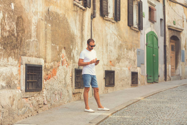 istock Modern guy using cellphone in the European city. 826476010
