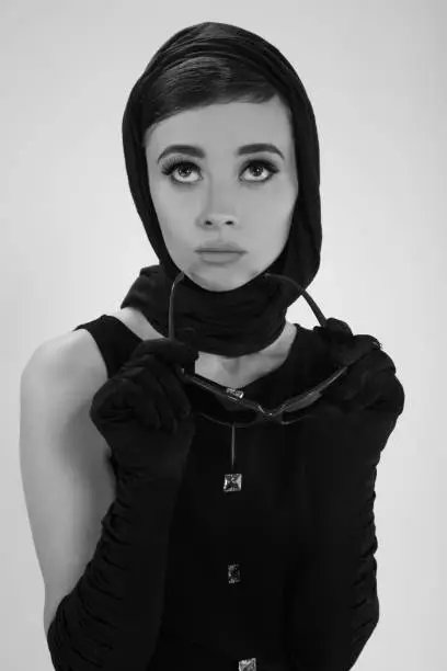 beautiful young woman in retro style with sunglasses and a head scarf black and white photography
