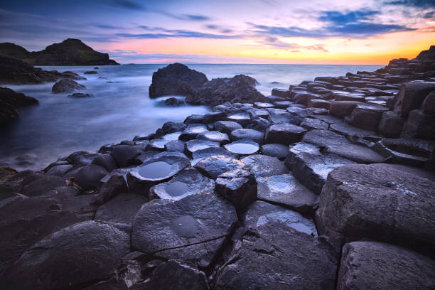 puesta de sol sobre las rocas formación calzada del gigante, condado de antrim, irlanda del norte, reino unido - national trust northern ireland uk rock fotografías e imágenes de stock