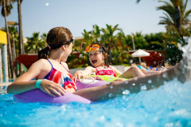 istock Kids having fun on innertubes in swimming pool 826494450