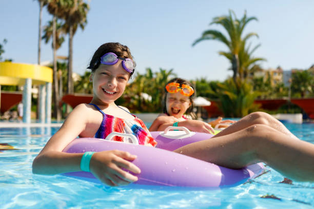 ragazze che galleggiano sul giocattolo della piscina della camera d'aria - water sport family inner tube sport foto e immagini stock
