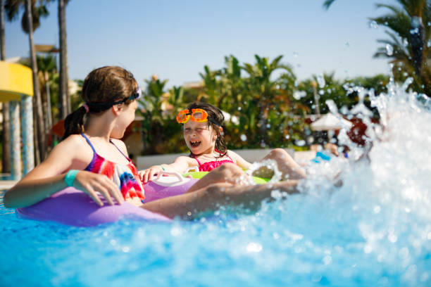 istock Kids having fun on innertubes in swimming pool 826494616