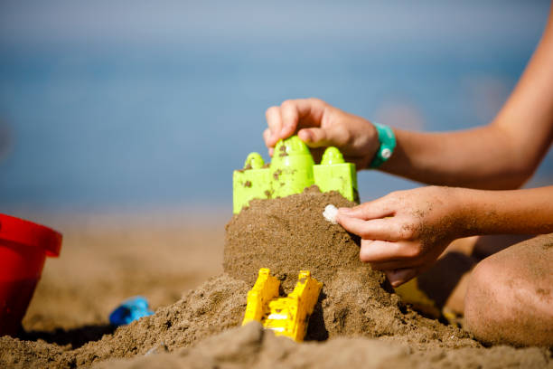 Building castle on beach with toy