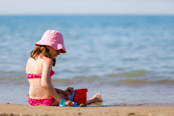 Girl, fishing and beach adventure for freedom, peace and learning skill development. Child, happy and ready with fishing net, bucket and fun outdoor activity, portrait and happiness in sunshine
