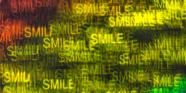 istock Beautiful background with different colored word smile, abstract background, smile shapes on black background 826511398