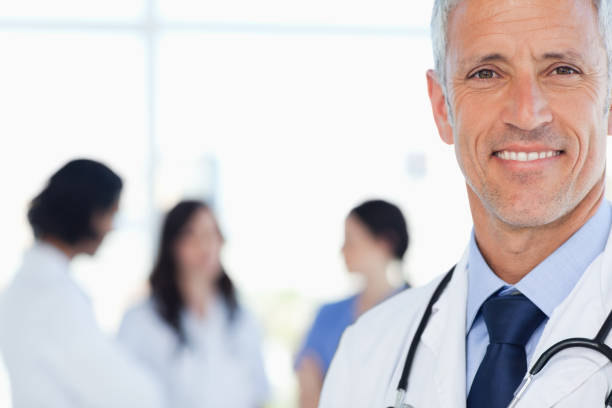 istock Smiling doctor with his medical interns behind him 826515886