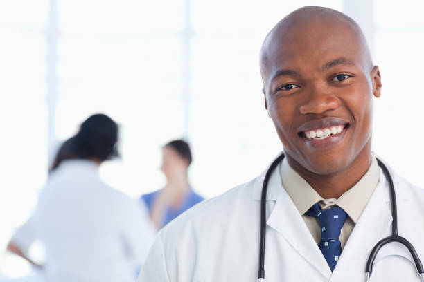 istock Smiling doctor standing with his stethoscope around his neck 826515952