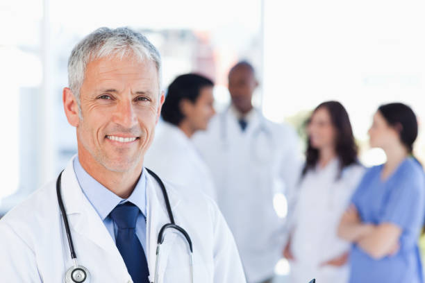 istock Mature doctor standing upright while waiting for his team 826518570