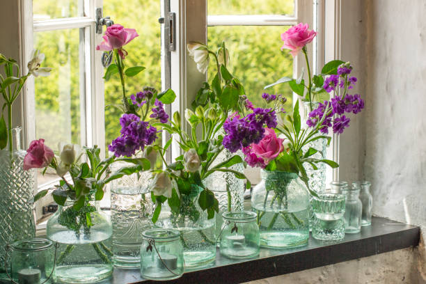 istock Jars of flowers on windowsill 826519546