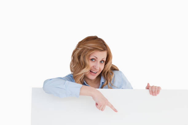 istock Cute blondhaired woman standing behind a white board 826519628