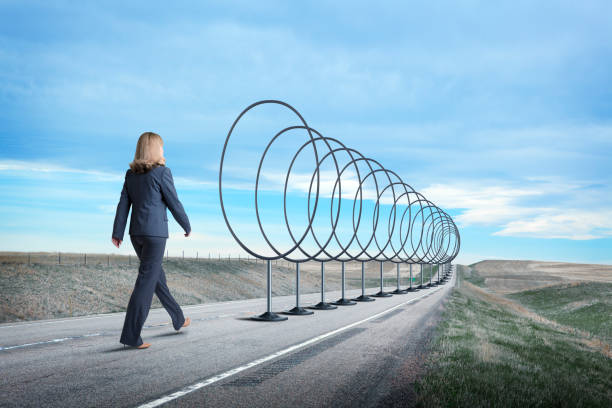 Businesswoman Walking Down Road Lined With Hoops