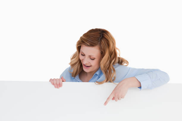 istock Attractive blondhaired woman standing behind a white board 826520260