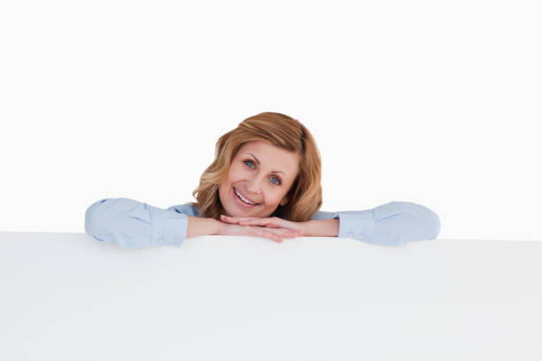 istock Smiling blondhaired woman standing behind a white board 826521276