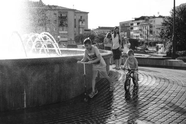 Families playing at city fountain at springtime. Photo taken May 30th, 2021, Zurich, Switzerland.