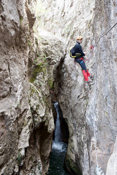 istock guy hanging from the rope with a waterfall behind 826523840