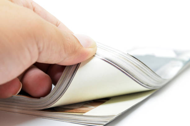 istock Hand through the pages of the magazine 826531002