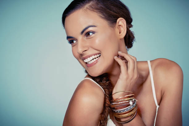 She enjoys the little things in life like great hair Studio shot of a beautiful young woman posing against a green background bangle stock pictures, royalty-free photos & images