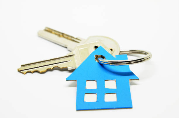 Old worn door with key in lock and many other keys in key ring