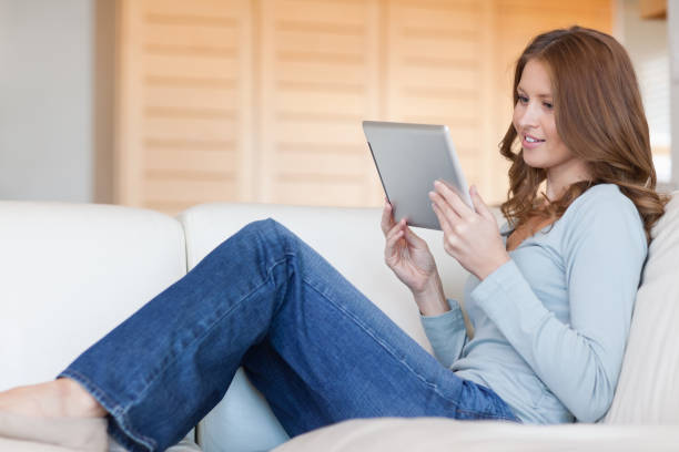 istock Woman reading ebook on the sofa 826545586