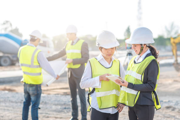 istock Engineer and builder review blueprint during team meeting at construction site 826548312