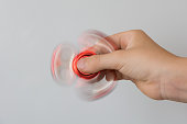 Fidget red spinner stress in hand on white.