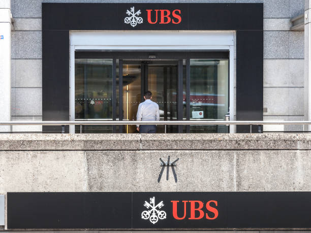 hombre entrar en una sucursal de ubs (union bank suiza) en ginebra. ubs es uno de los principales bancos del país, famoso por su secreto bancario - geneva canton fotografías e imágenes de stock