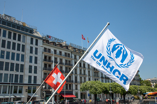 Picture of the swiss and UNHCR flags next to each other in Geneva, near the leman lake