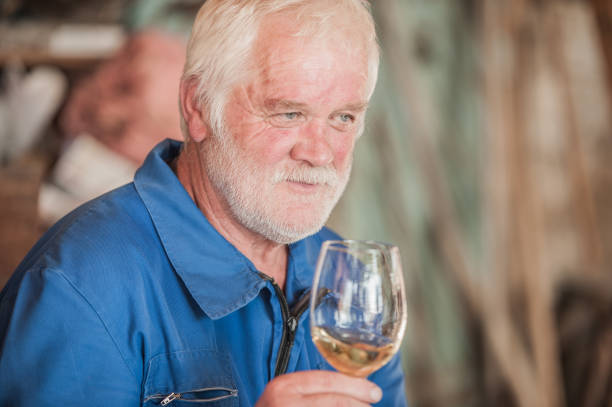 istock Senior Man with Beard Holding Glass of White Wine 826556490