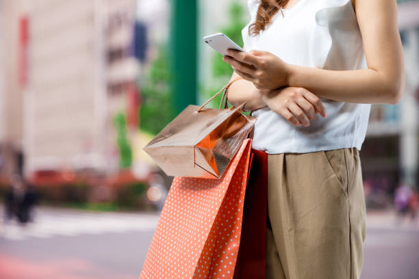 istock shopping concept. woman using smart phone with shopping bag. 826567472