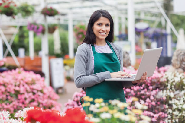 istock Woman using laptop in the garden center 826570982