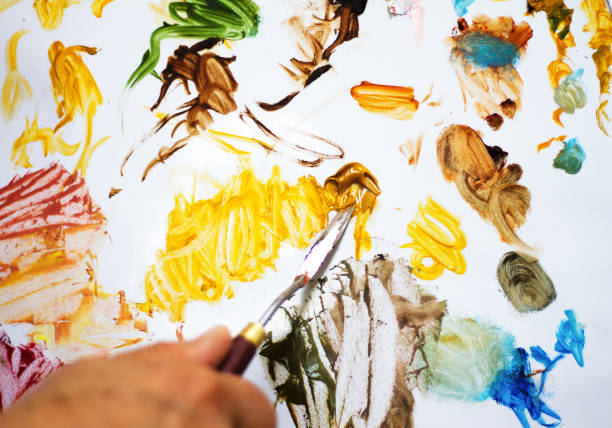 istock Artist's Hand Mixing Oil Paints on Palette (Close-Up) 826571350