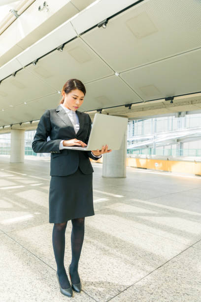 woman holding laptop in office building